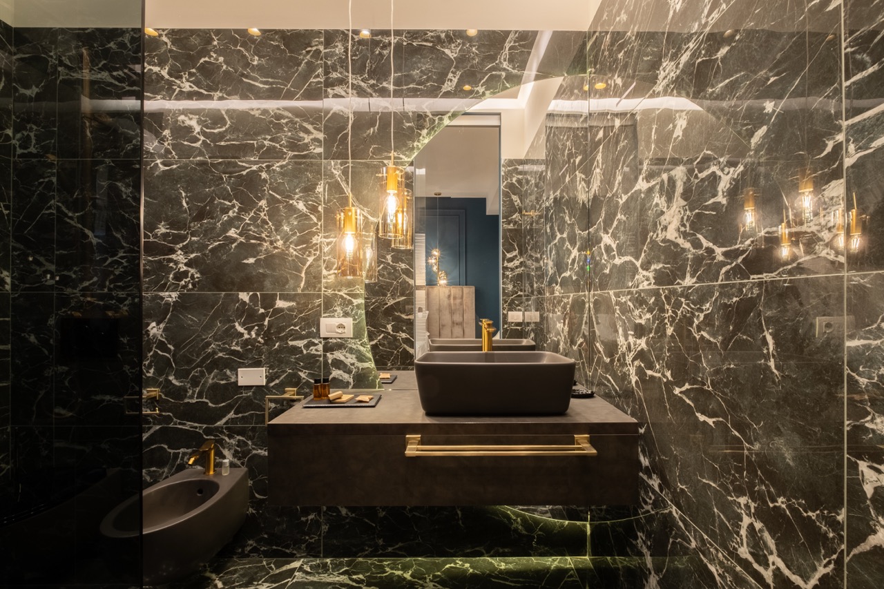 Dark marble bathroom vanity with gold fixtures
