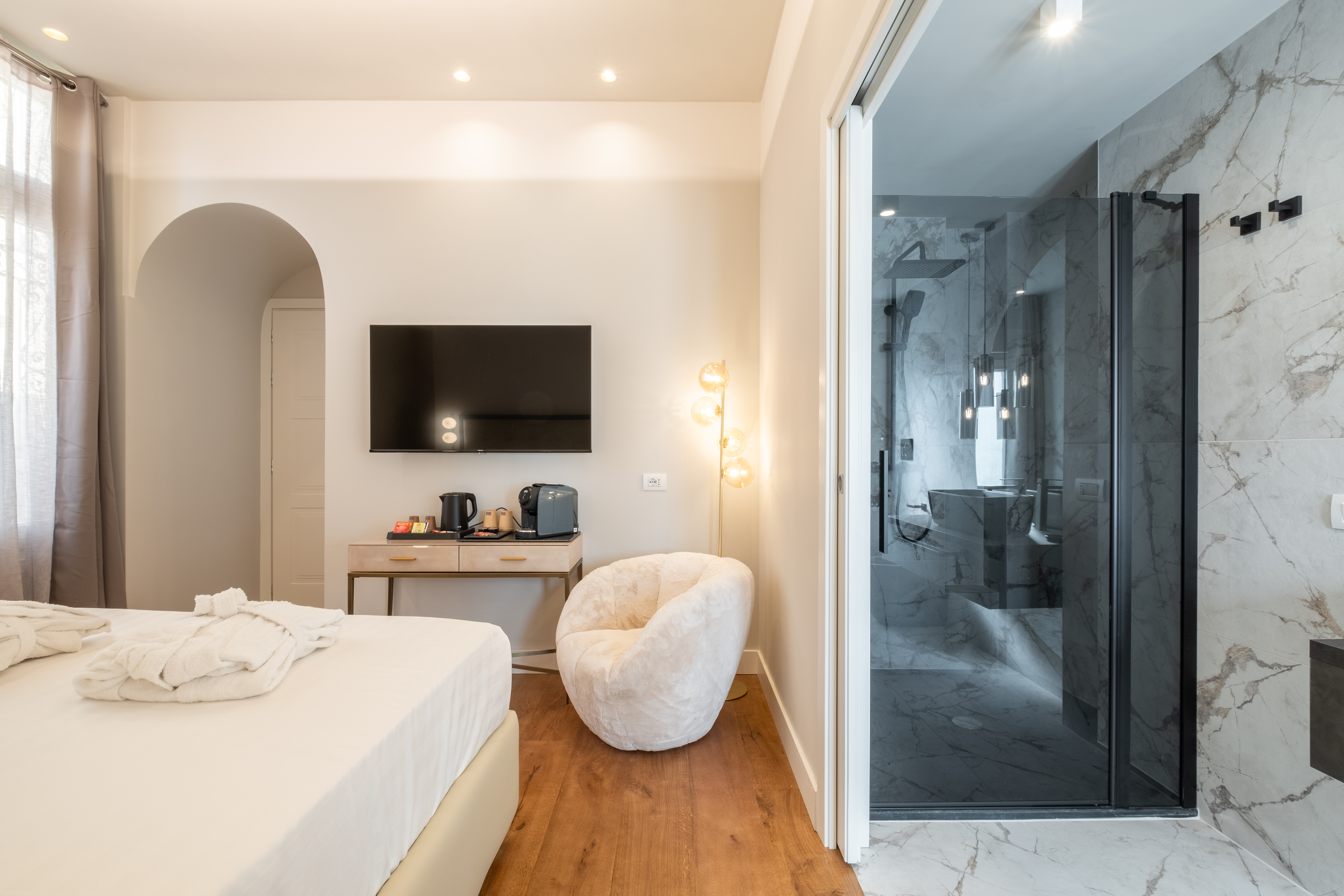Stampace suite with plush armchair and marble bathroom