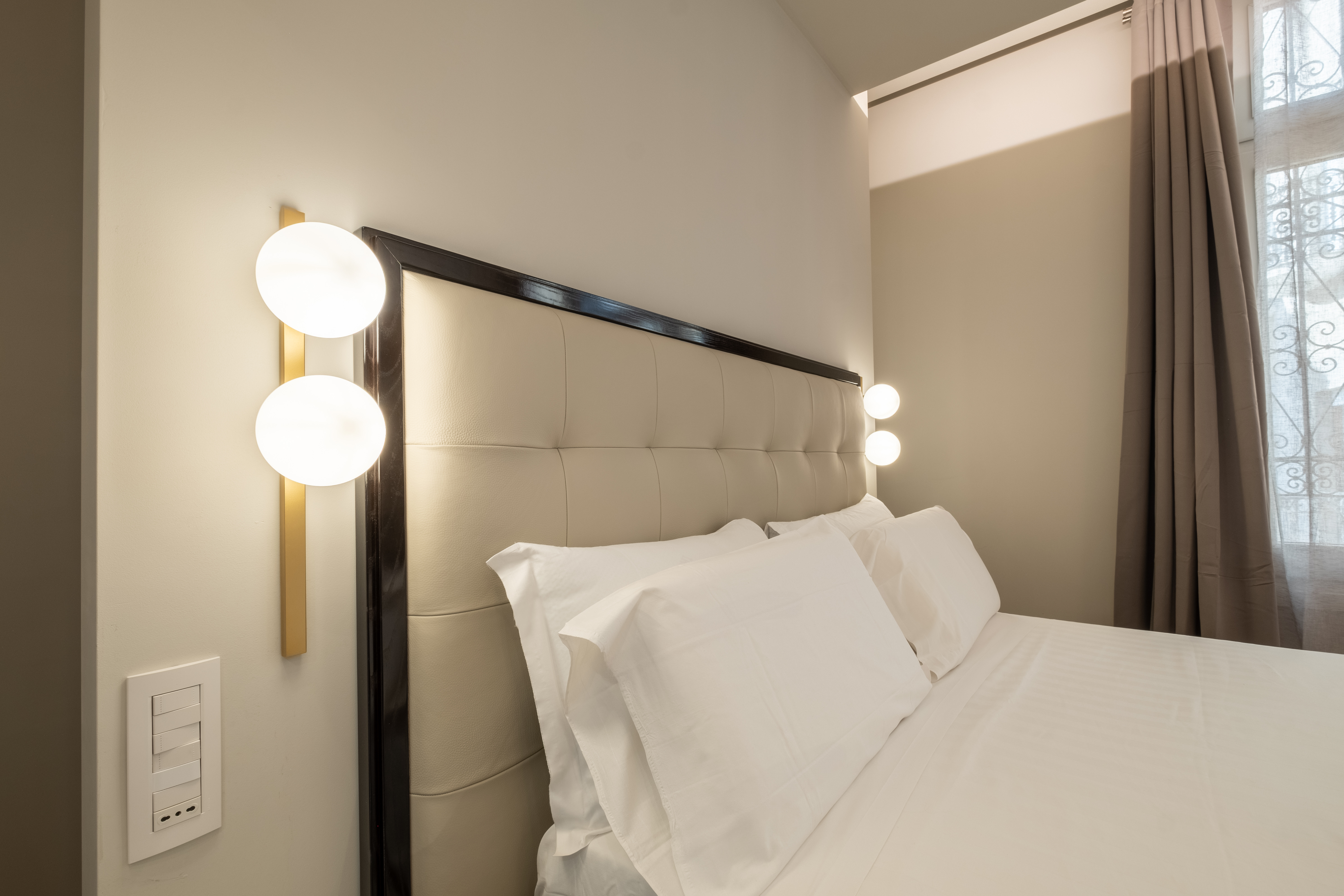 Tufted headboard with gold wall sconces